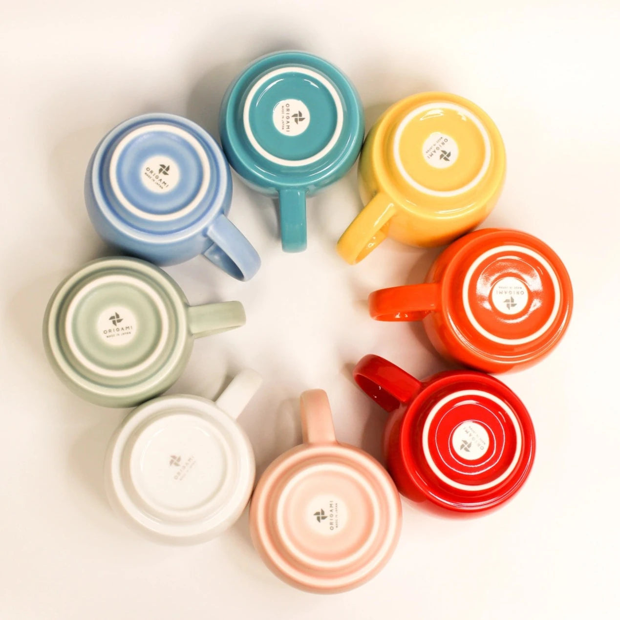 Bottom view of eight ORIGAMI Aroma Stacking Mugs laid in a circle
