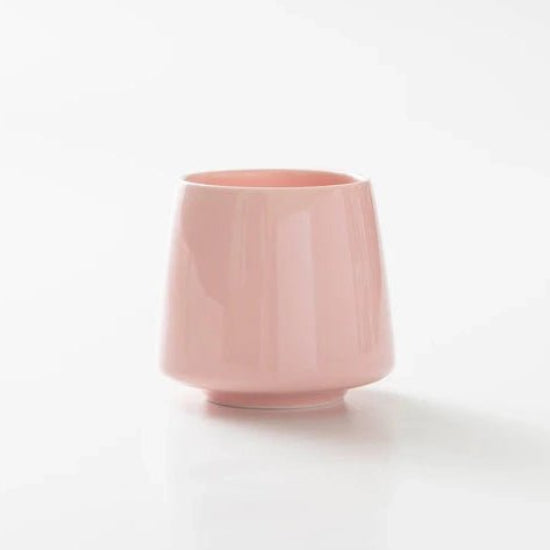 Pink ceramic cup on a white background