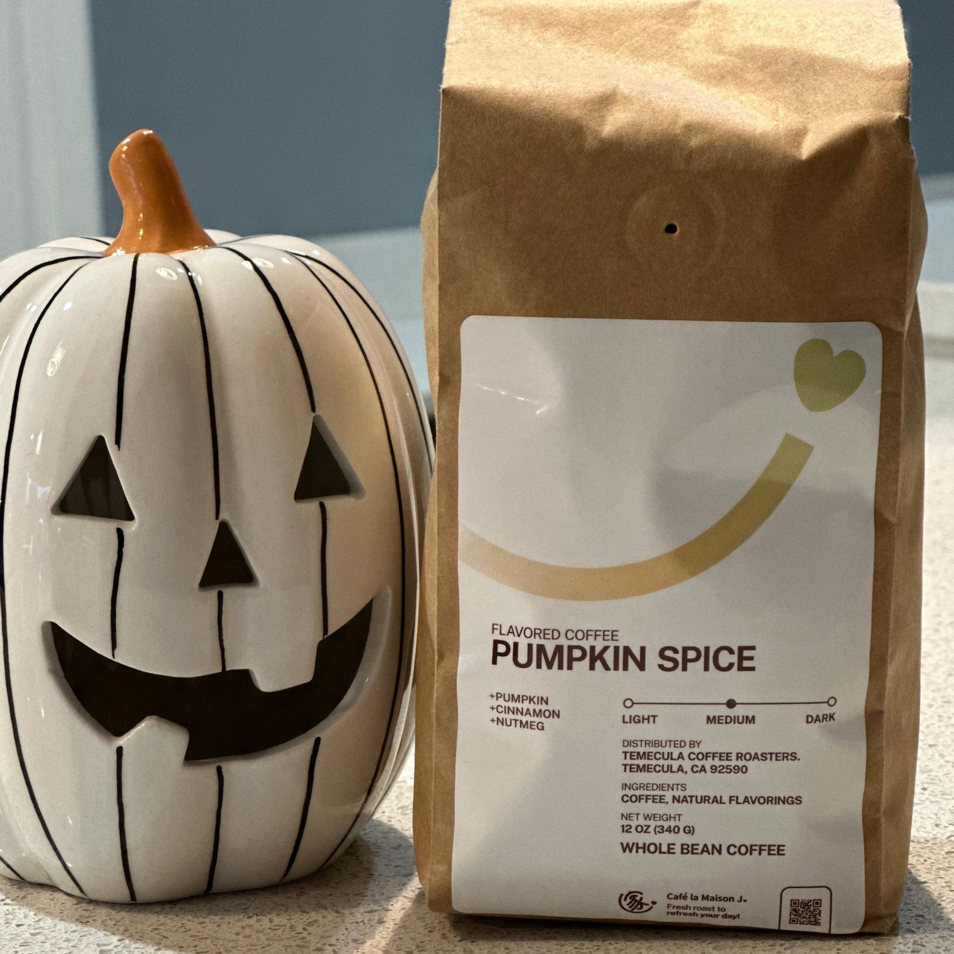 Pumpkin Spice  flavored coffee bean in a kraft bag  and next to a jack-o-lantern