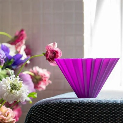 It shows a purple AS resin ORIGAMI Coffee Dripper Air S is next to a colorful bouquet 