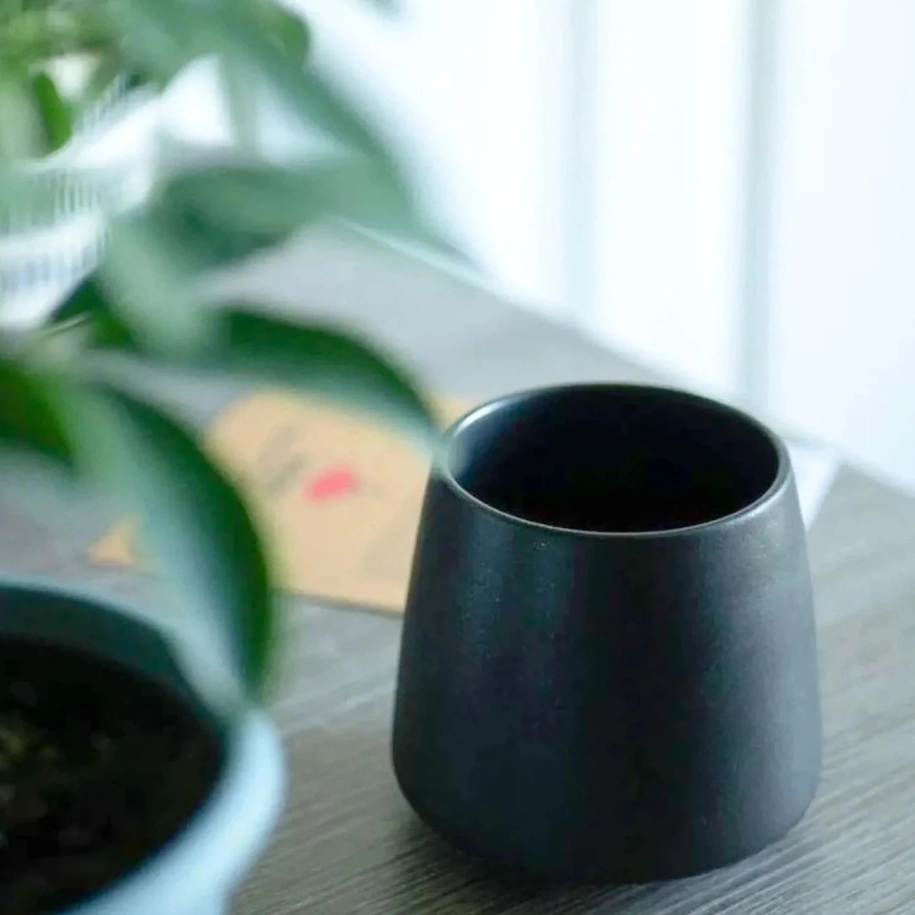 A matte black ORIGAMI Aroma Flavor Cup on a table