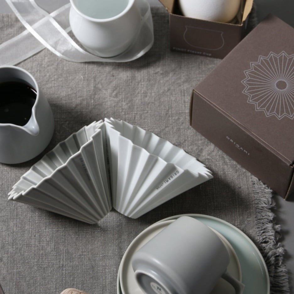 White and Grey Origami Coffee Drippers and Other Tablewares on a Velvet Surface 