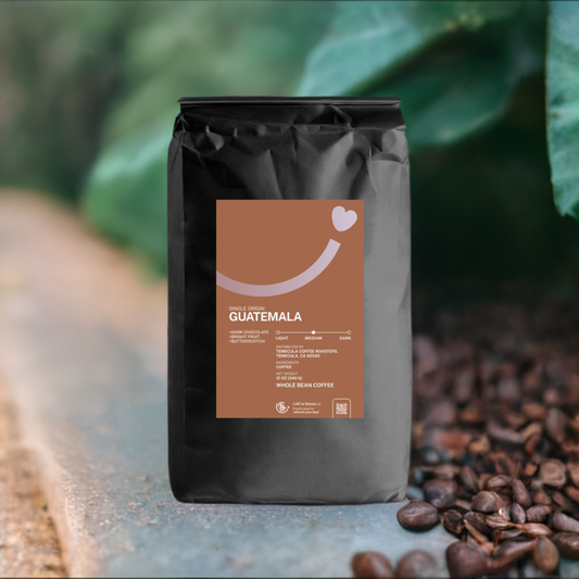 a bag of single origin Guatemala Antigua with green leaves and coffee beans backdrop