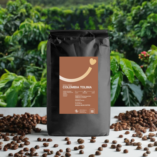 A bag of Colombia Tolima coffee in front of bushes