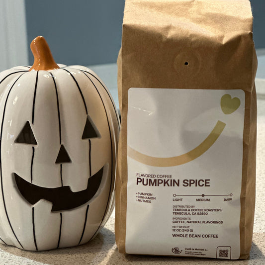 a 12oz whole bean Pumpkin Spice flavored coffee next to a jack-o-lantern pumpkin