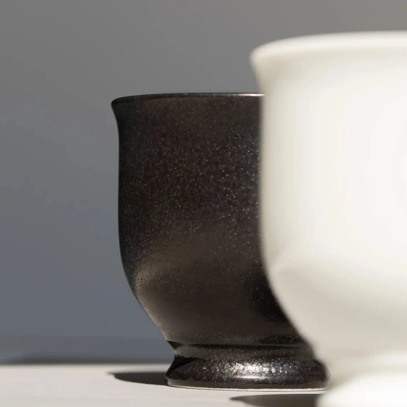 A zoom in look of a black and a white ORIGAMI Sensory Filter Cup