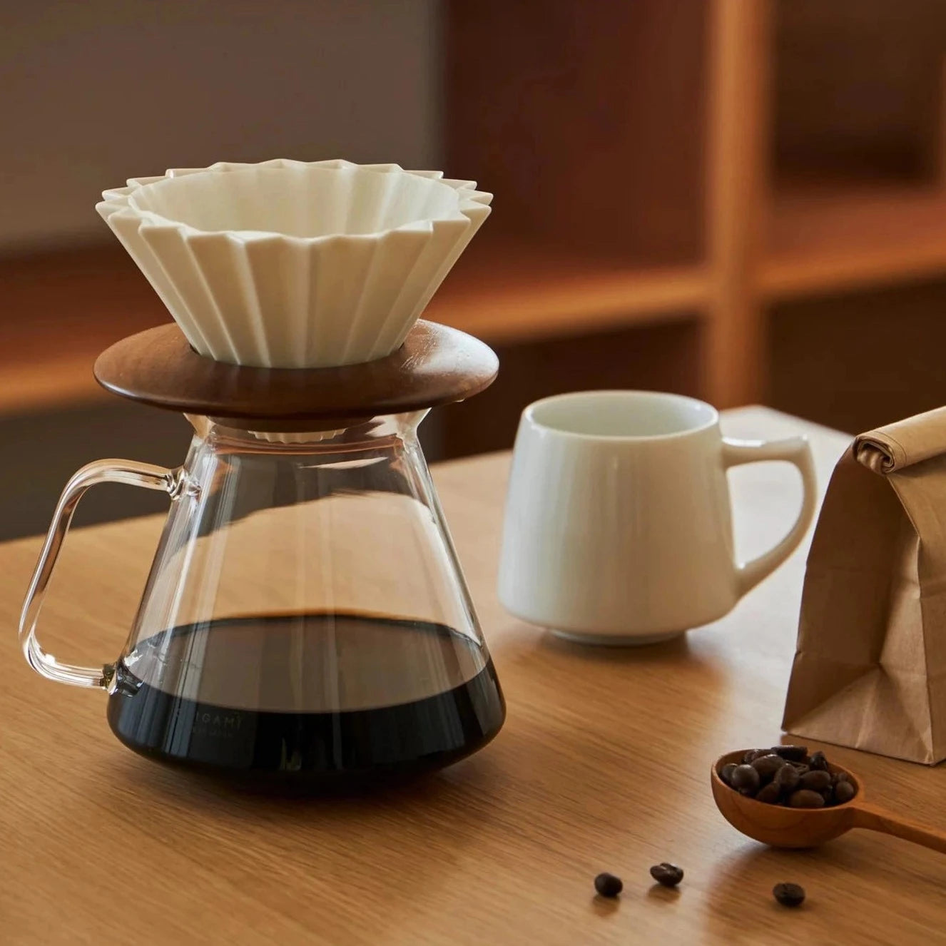 A table set of ORIGAMI JAPAN products, including porcelain dripper, wood dripper holder, ORIGAMI x HARIO glass server and Aroma Mug